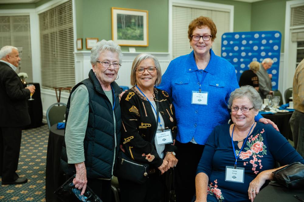Four alumnae pose for a photo together at the Reunion Dinner.
